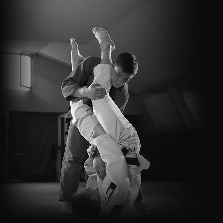 Dois homens lutando Jiu Jitsu na academia MFC em Balneário Camboriú